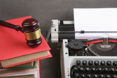 Type writer next to a gavel and law books